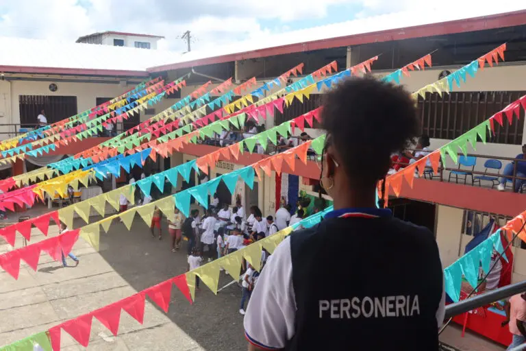 Niña viendo el patio de un colegio con banderines